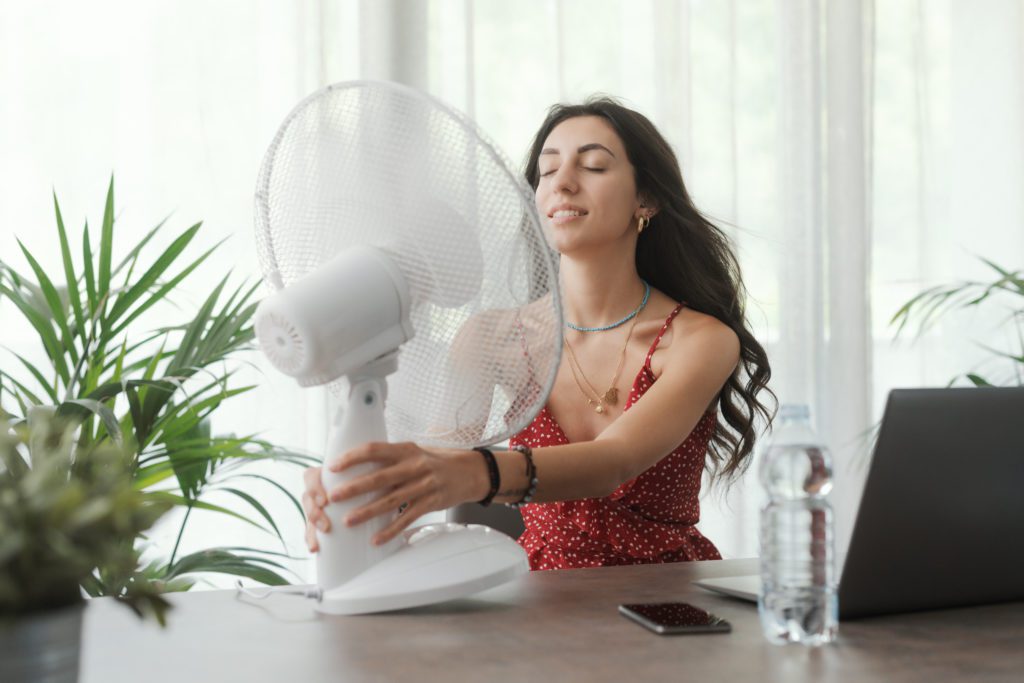 Woman cooling herself at home